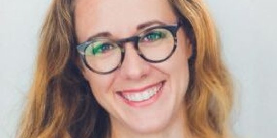 headshot, blonde female wearing glasses.