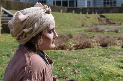 Actor performing Trojan Women outdoors - solemn