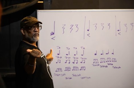 Guest artist Carlos Jones teaches from a whiteboard