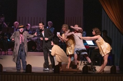 A downtrodden clown on stage with well-dressed actors in 'Chicago' 