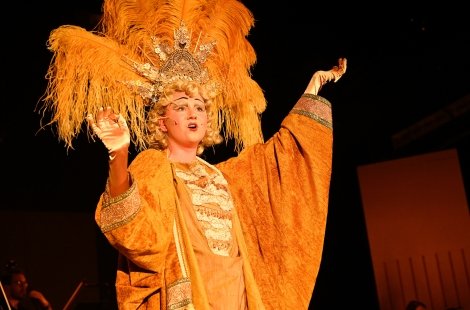 Actress in orange costume with big feather headpiece
