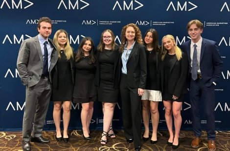 8 students in business attire at the American Marketing Association conference