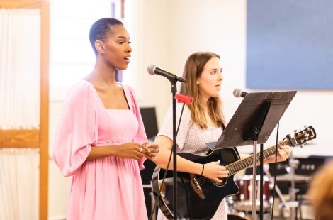 Student sings while another plays the guitar at SRYou day