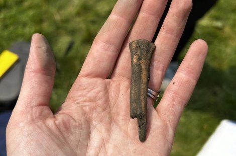 Unearthed object held in the open palm of a hand