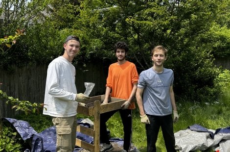 Three male students working on an archaeological dig