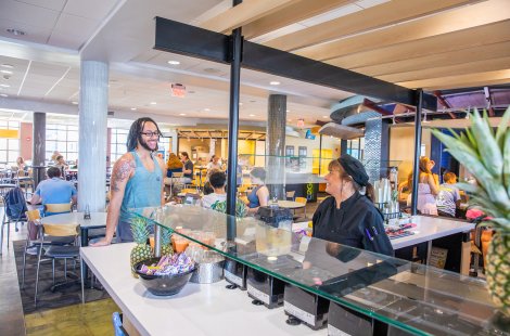 A man talks to a female employee in a cafeteria