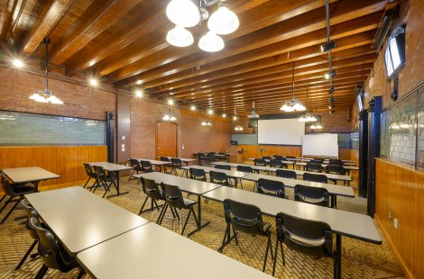 A classroom with rows of tables and chairs.