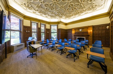 A large classroom with a high, ornate ceiling.