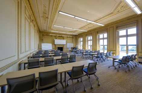 A large classroom with a high, ornate ceiling.