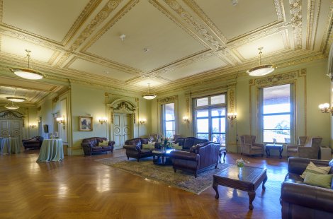 A large common area with comfortable furniture and a high, ornate ceiling.