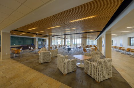 A common area of an academic building with many tables and chairs.