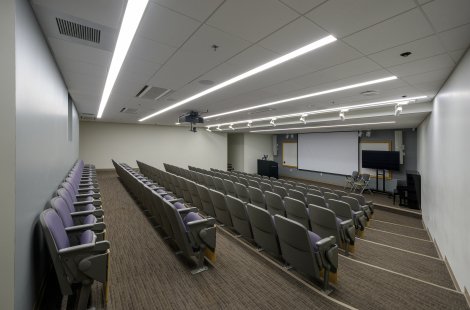 A small lecture hall with a podium and large screen at the front.