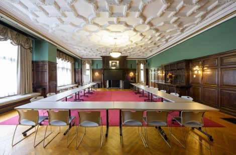 A large boardroom with a high, ornate ceiling.