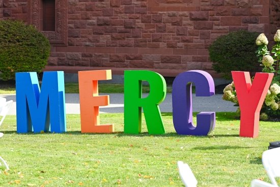 Large colorful letters that spell out 'MERCY' on the lawn.