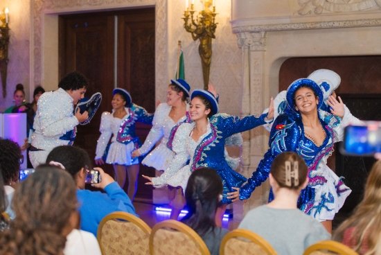 Dancers in sparkly blue and white outfits dancing in Ochre Court.
