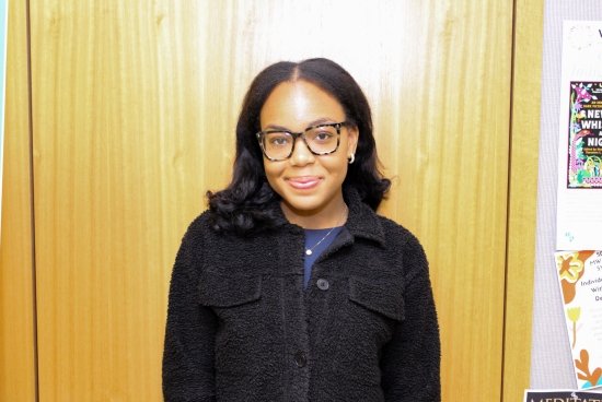 Headshot of Marsara in black jacket, standing in front of wooden wall.