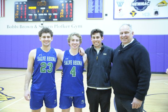 group photo of Brochu family, two in their Salve basketball jerseys, all smiling on the basketball court.