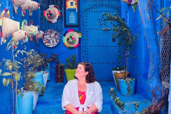 Student sitting in a colorful doorway with Moroccan objects 
