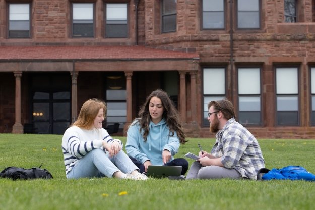 three students studying outside