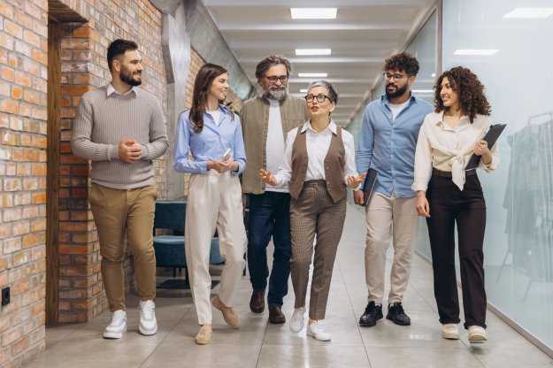 Business team walking through office hallway, talking and collaborating