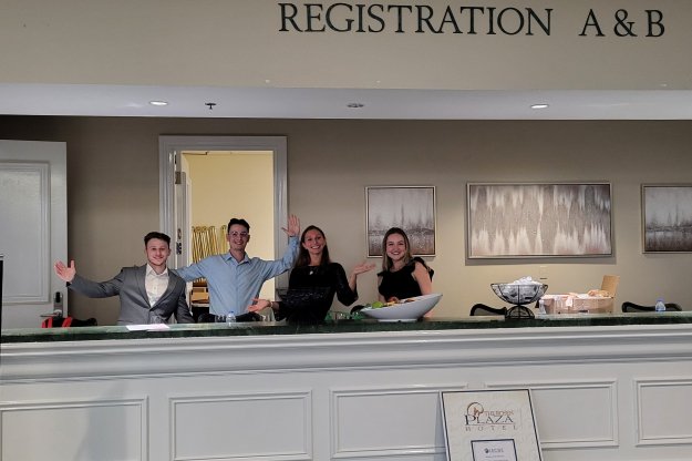 students work at hotel registration desk