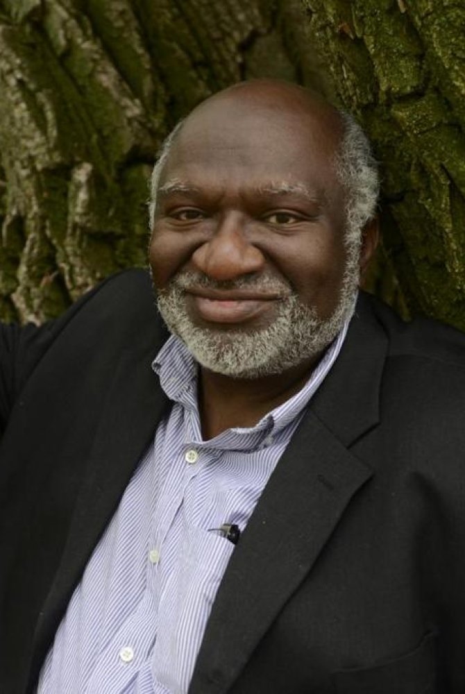 Headshot of Charles Coe leaning against the trunk of a tree