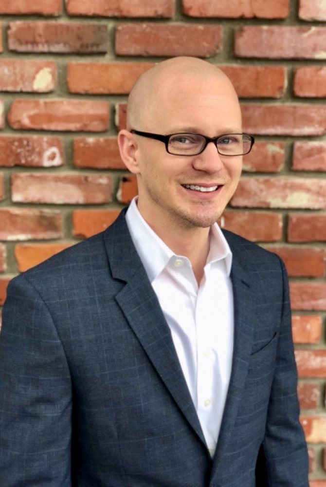Joseph Cihon standing against a brick wall