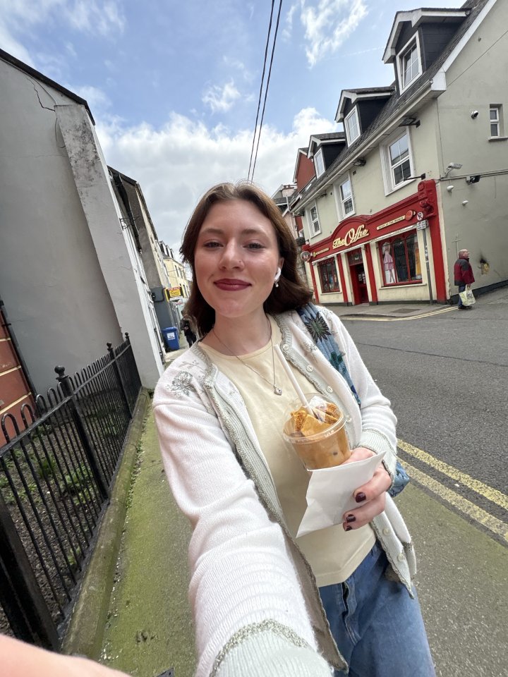 Fiona Albright walking along a road in Ireland with white stucco buildings lining the street