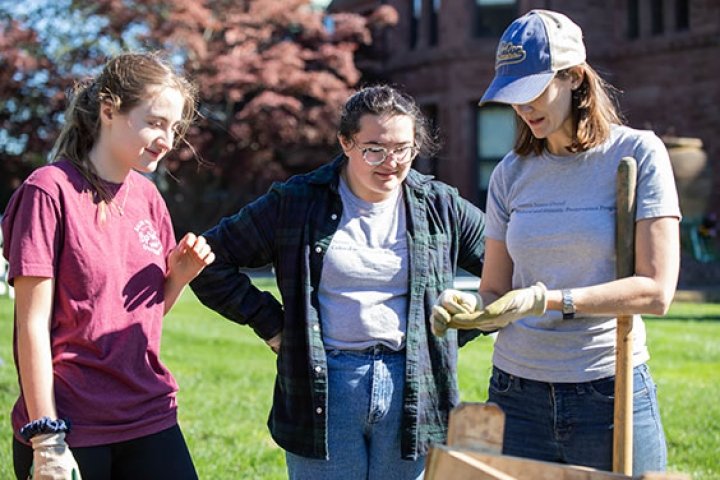 Students and a professor examining archaeological artifacts