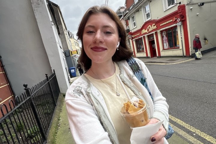 Fiona Albright walking along a road in Ireland with white stucco buildings lining the street