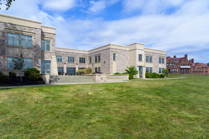 A large, two-story brick building with a wide lawn in front.