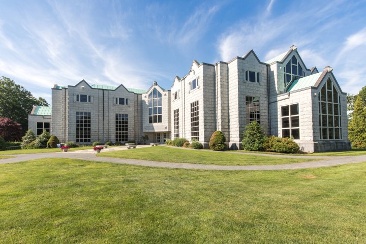Exterior of a white brick academic building with tall windows.