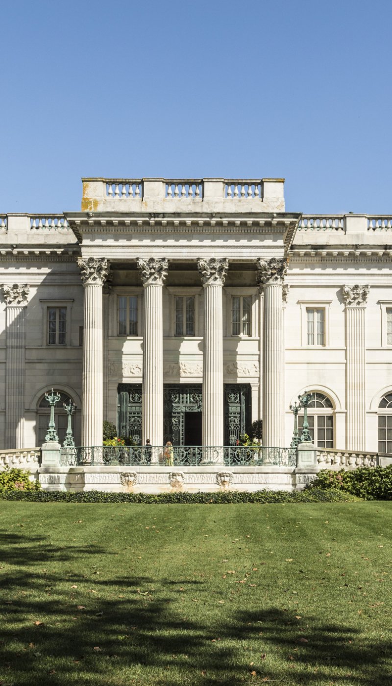 A large marble mansion with white columns in the front.