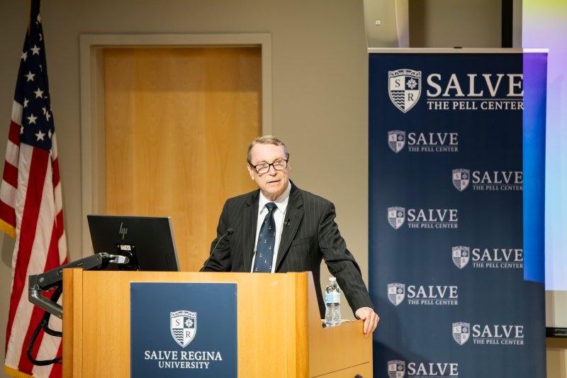Craig Symonds standing at a podium giving his McGinty Lecture, with Salve branding and an American flag behind him.