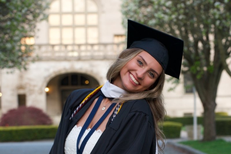 Valedictorian Jenna Martin in front of Ochre Court in her cap and gown.