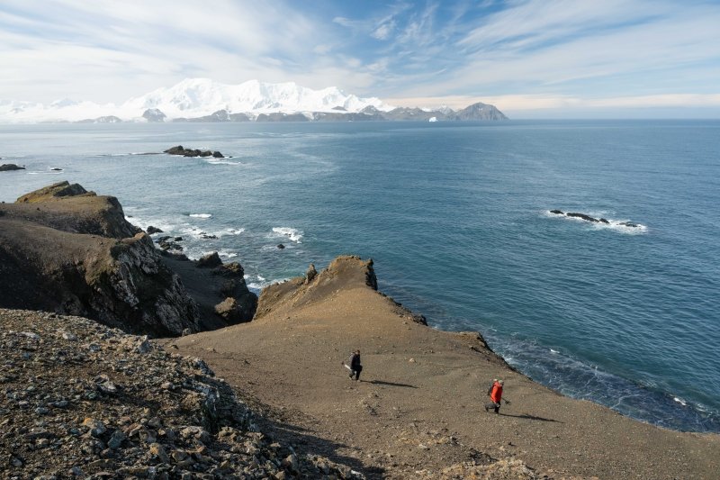 Dr. Jesse Casana (front) and Kitchel carrying survey equipment on Livingston Island.