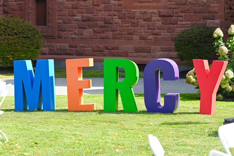 Large colorful letters that spell out 'MERCY' on the lawn.