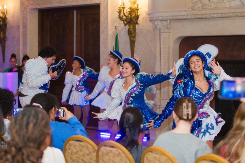 Dancers in sparkly blue and white outfits dancing in Ochre Court.
