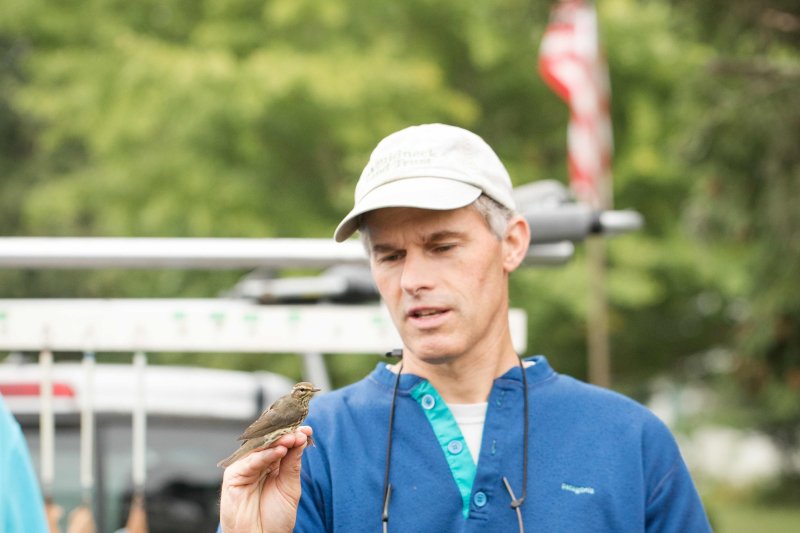 Dr. Jim Chace with a bird perched on his hand.