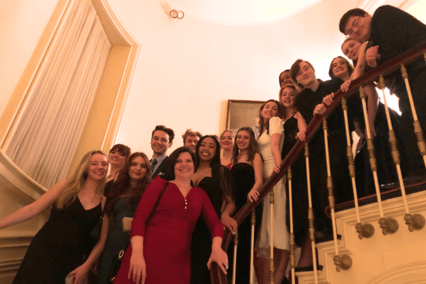 Students lining the staircase of the Lotos Club for a group photo with Dr. Tara Brooke Watkins.