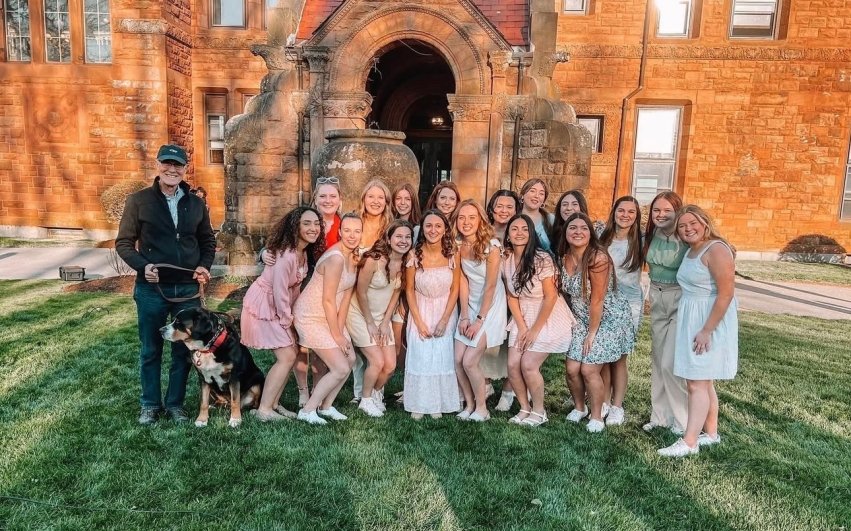 Group photo of Salve's all-female a cappella group "Pitches with Attitude" outside of McAuley Hall.