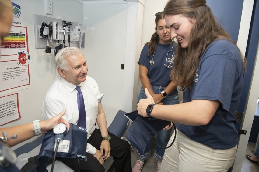 U.S. Senator Jack Reed learns the importance of preventative care from Salve Regina University nursing students in the school's new health and wellness educational mobile unit.