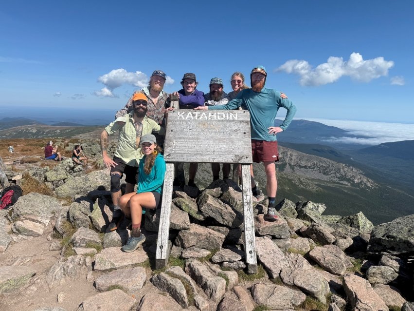 Crocker and friends posing behind a sign for "Katahdin"