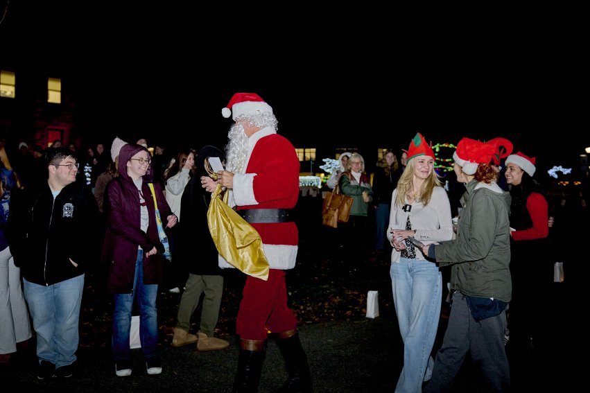 Santa giving out treats to students, families and children at annual Christmas tree lighting.