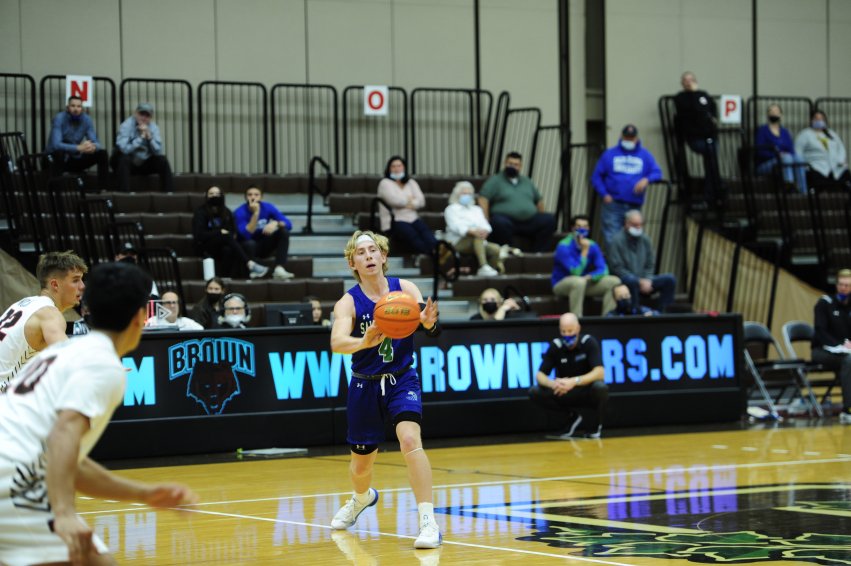 Action shot of Clay passing the basketball during a game.
