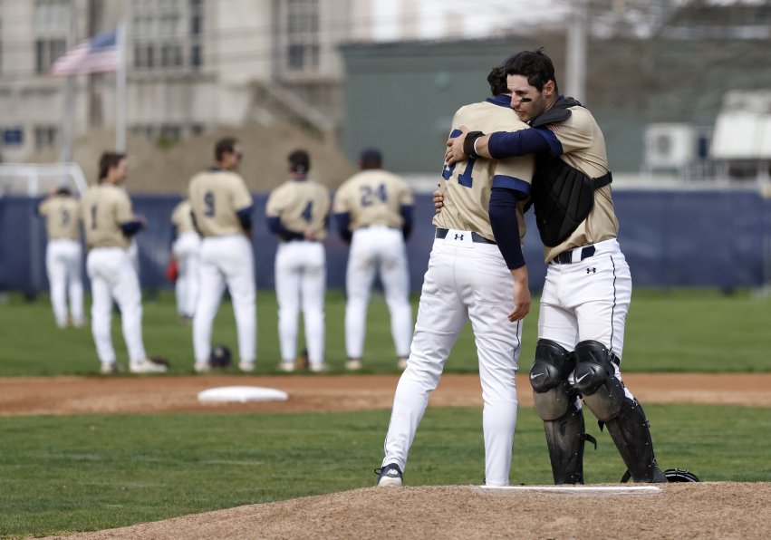 two baseball players hugging on the mound.