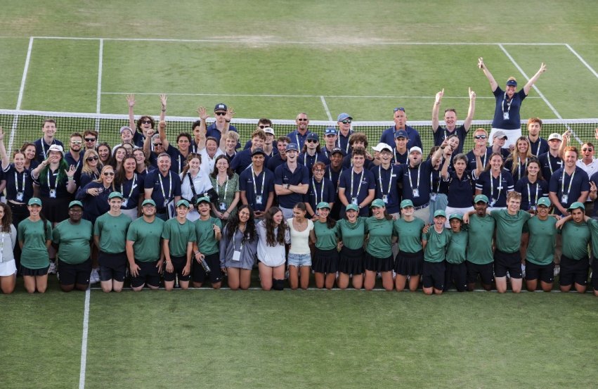 Group of staff and interns on a grass court at the International Tennis Hall of Fame.