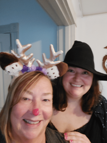 Two people dressed up at a witch and Rudolph the reindeer.