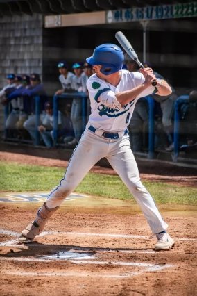 Grover in white baseball uniform swinging the bat