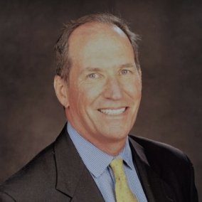professional headshot of Reilly in suit and tie.